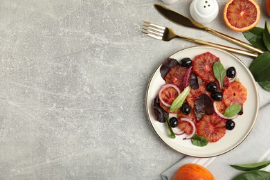 Photo of Delicious sicilian orange salad served on grey table, flat lay. Space for text