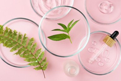 Photo of Petri dishes with different plants and cosmetic products on pink background, flat lay