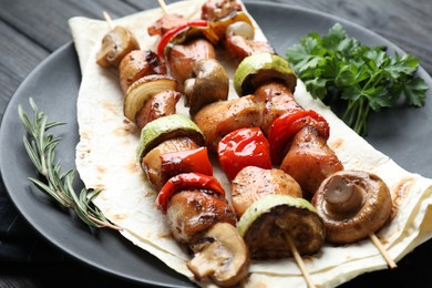 Photo of Delicious shish kebabs with vegetables and spices on table, closeup