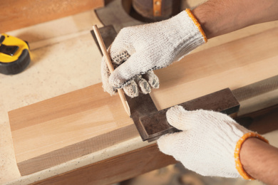 Photo of Professional carpenter working with wooden board at workbench, closeup