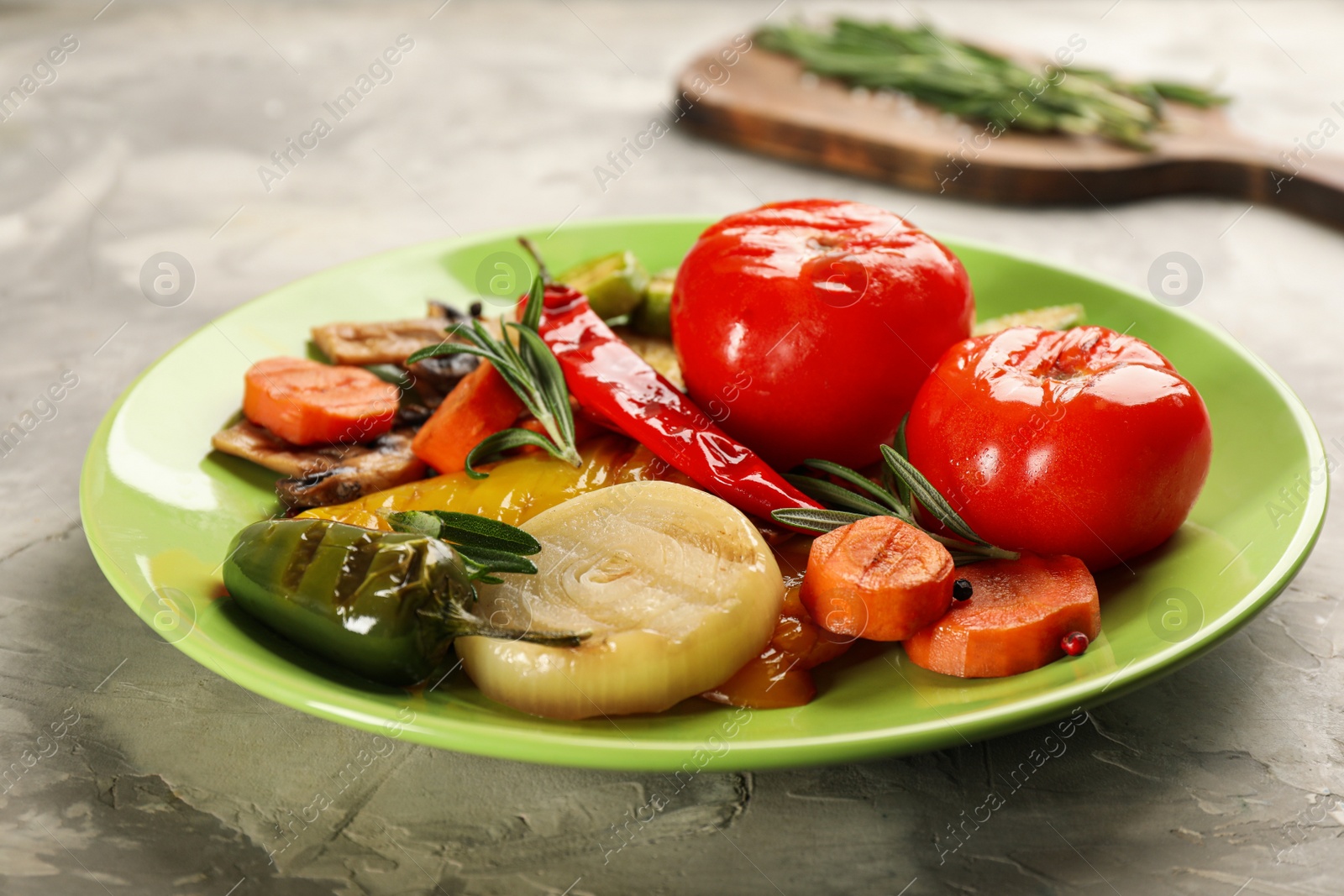 Photo of Delicious grilled vegetables with rosemary on light grey table, closeup
