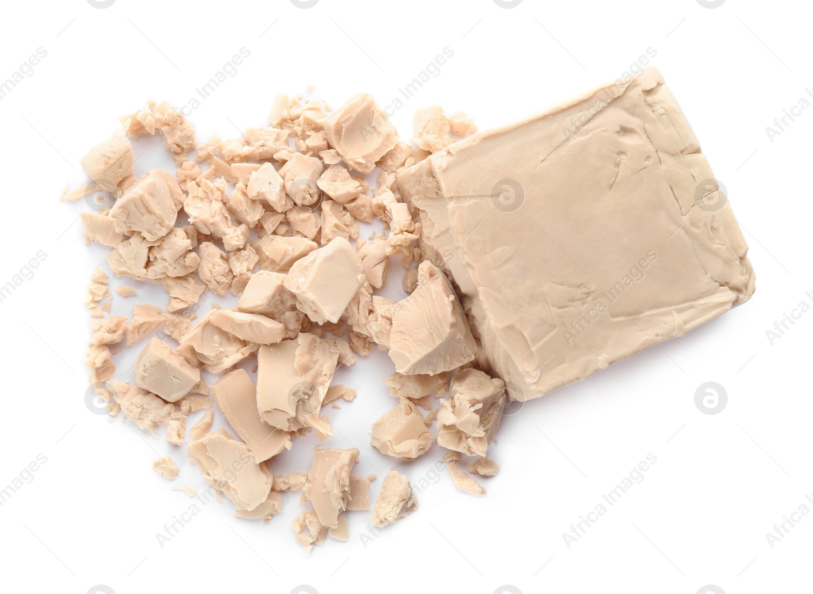 Photo of Crumbled block of compressed yeast on white background, top view
