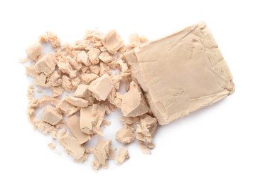 Photo of Crumbled block of compressed yeast on white background, top view