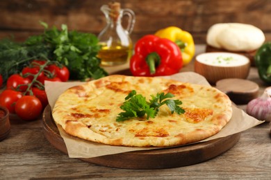 Photo of Delicious khachapuri with cheese on wooden table