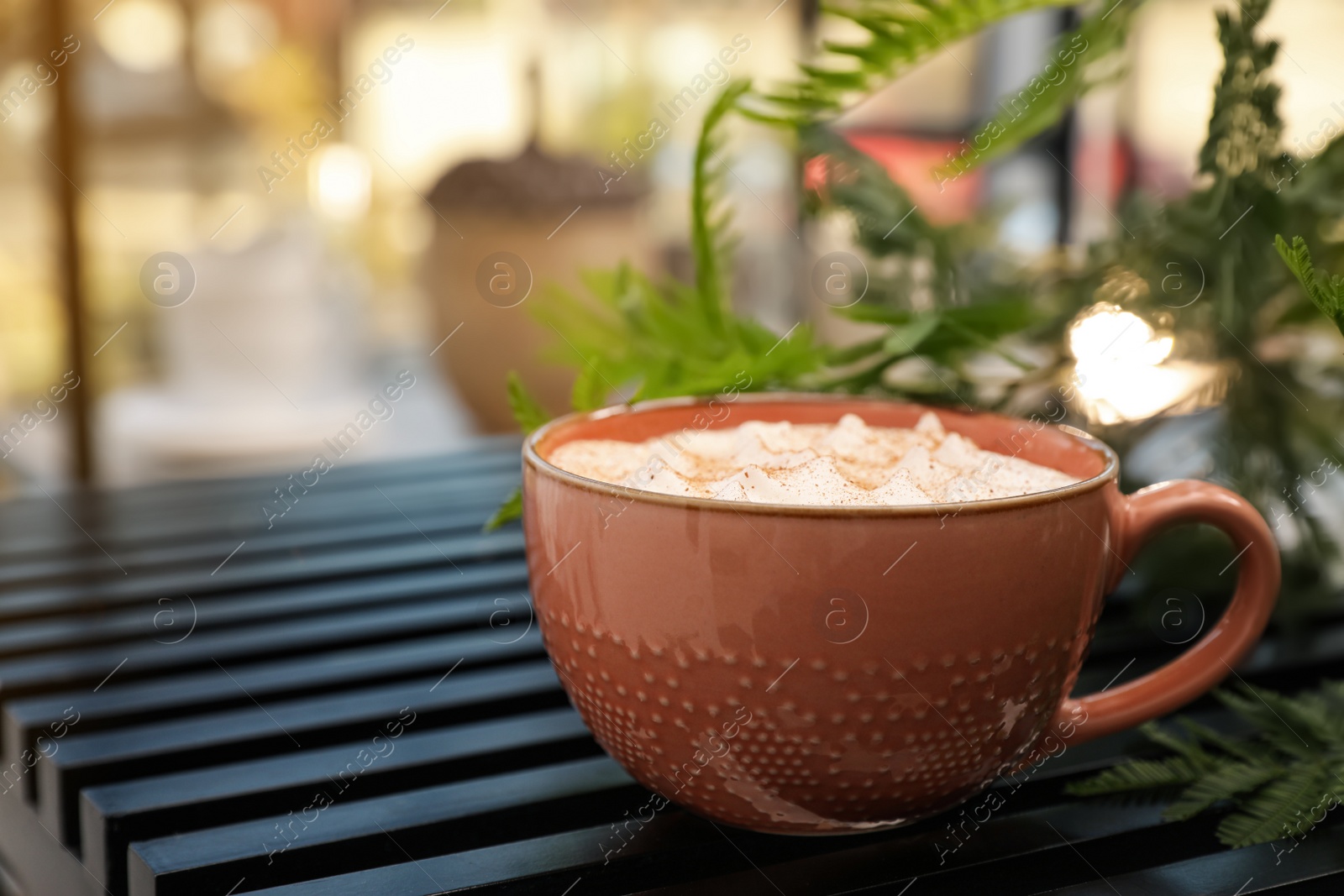 Photo of Ceramic cup of aromatic coffee with foam on wooden table in cafe. Space for text