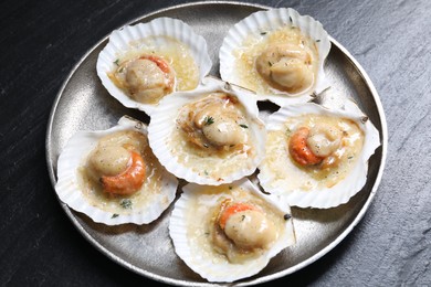 Fried scallops in shells on black table, above view