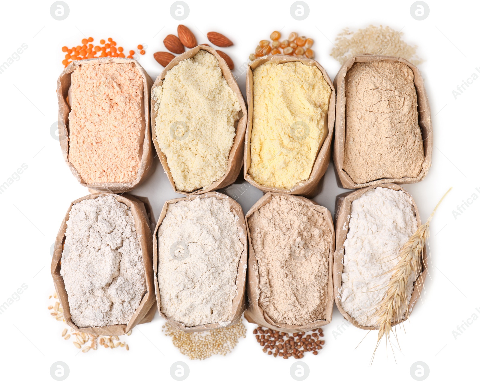 Photo of Paper bags with different types of flour on white background, top view