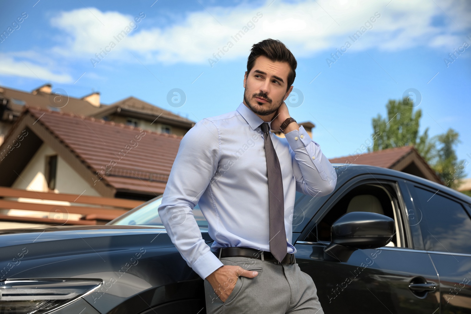 Photo of Attractive young man near luxury car outdoors