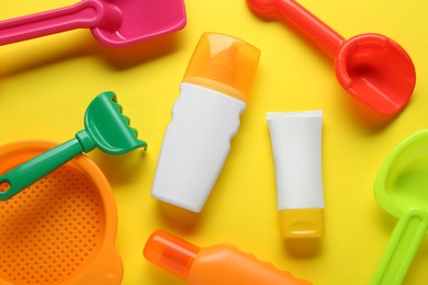 Photo of Suntan products on yellow background, flat lay