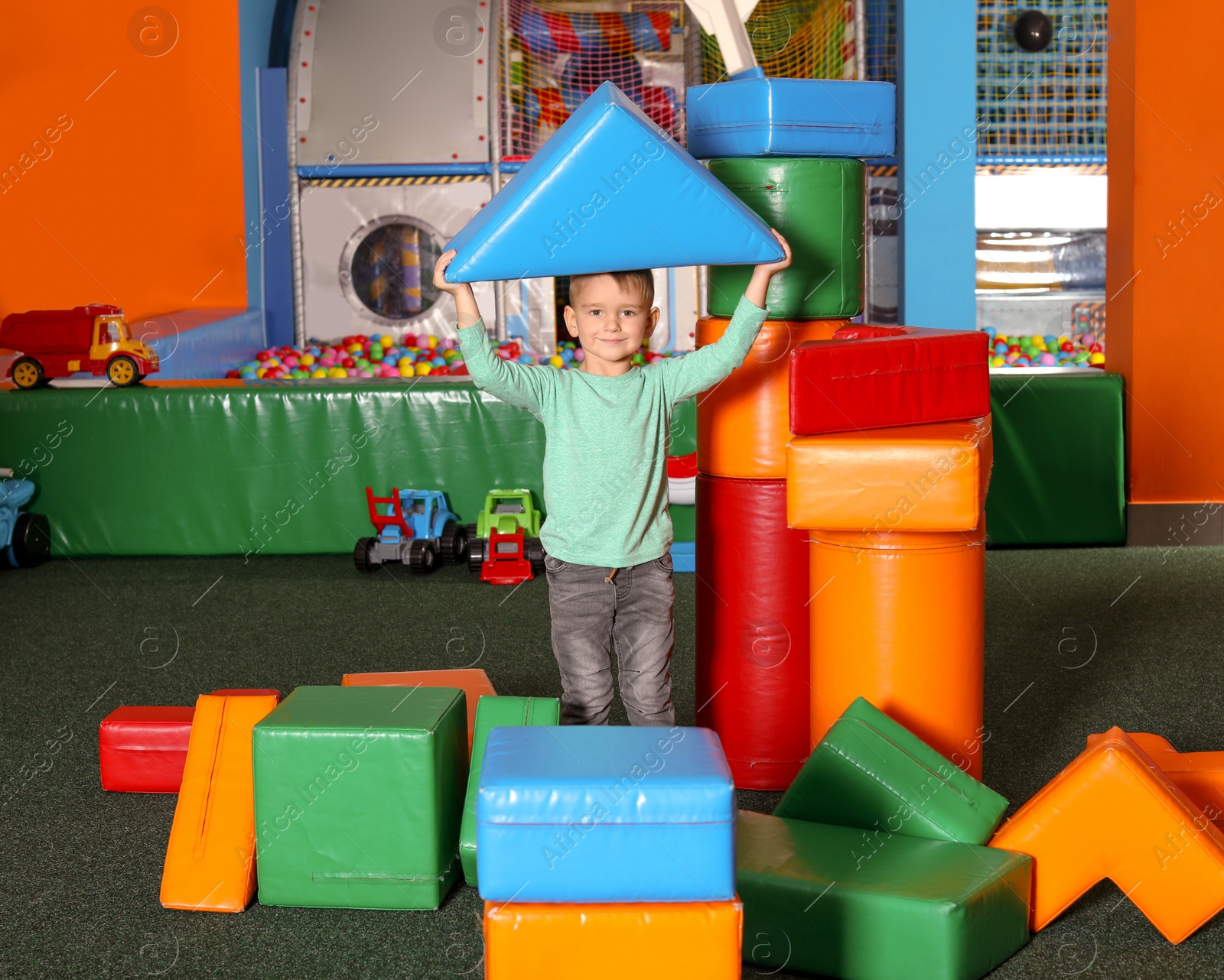 Photo of Cute child playing with colorful building blocks indoors