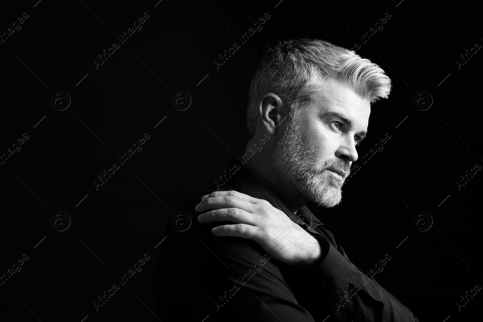 Photo of Portrait of handsome man on dark background, space for text. Black and white effect