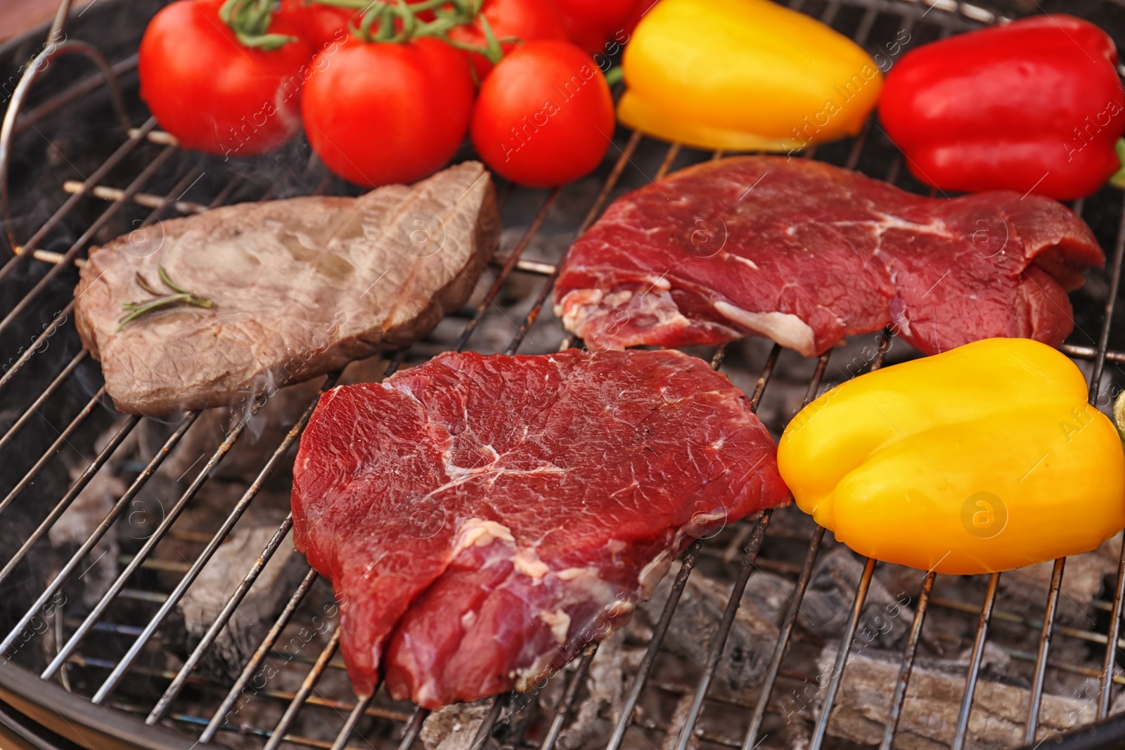 Photo of Modern grill with meat and vegetables outdoors, closeup