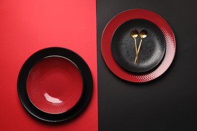 Stylish table setting with plates and spoons on color background, top view