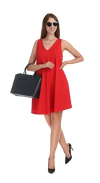 Young woman wearing stylish red dress with elegant bag on white background