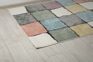 Soft carpet with pattern on white laminated floor indoors