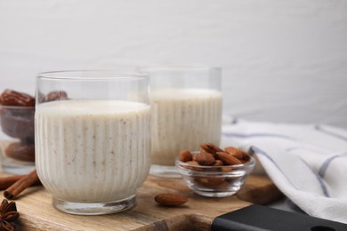 Glasses of delicious date smoothie and nuts on wooden board. Space for text
