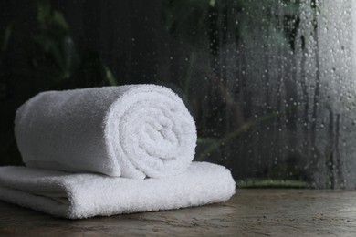 White terry towels on table in bathroom, space for text