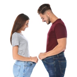 Photo of Fit people in oversized jeans on white background. Weight loss
