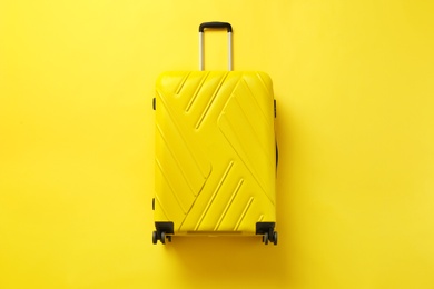 Photo of Stylish suitcase on color background, top view