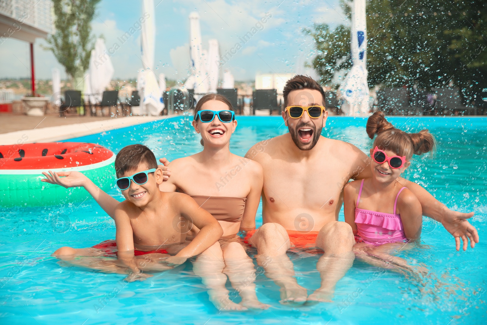 Photo of Happy family in swimming pool on sunny day