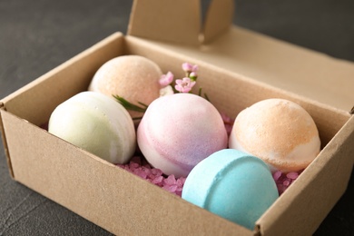 Carton box with bath bombs on black table, closeup