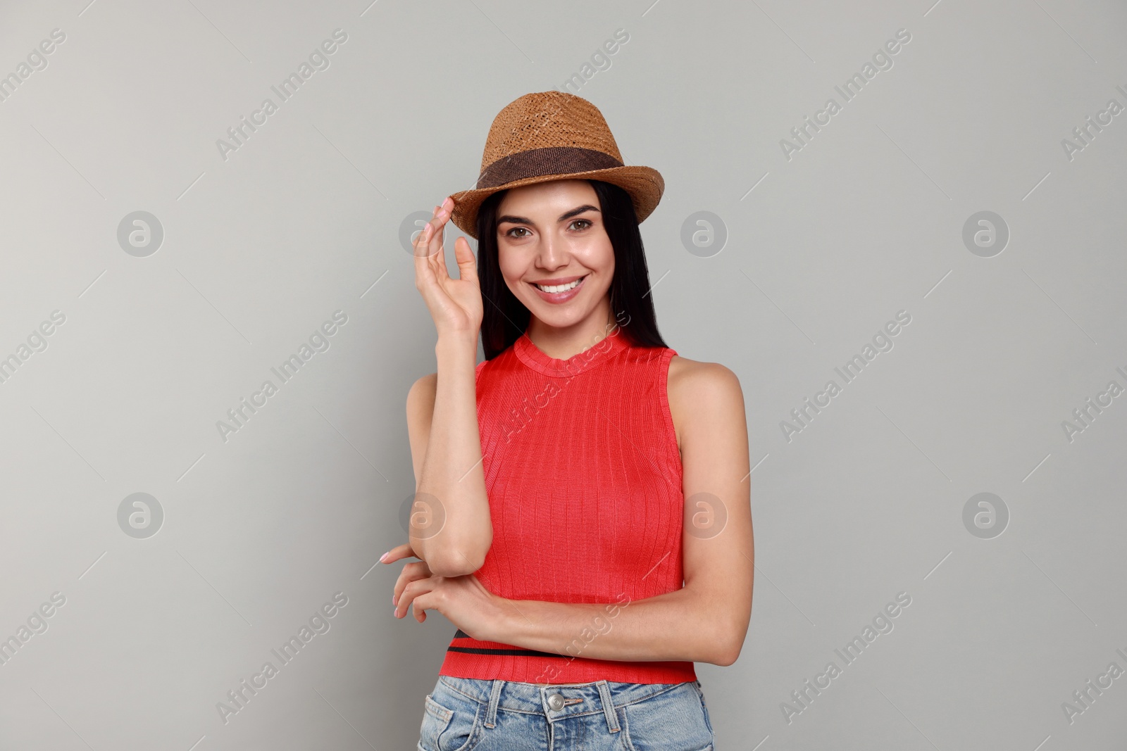Photo of Beautiful young woman with straw hat on light grey background
