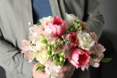 Man holding bouquet of beautiful flowers indoors, closeup