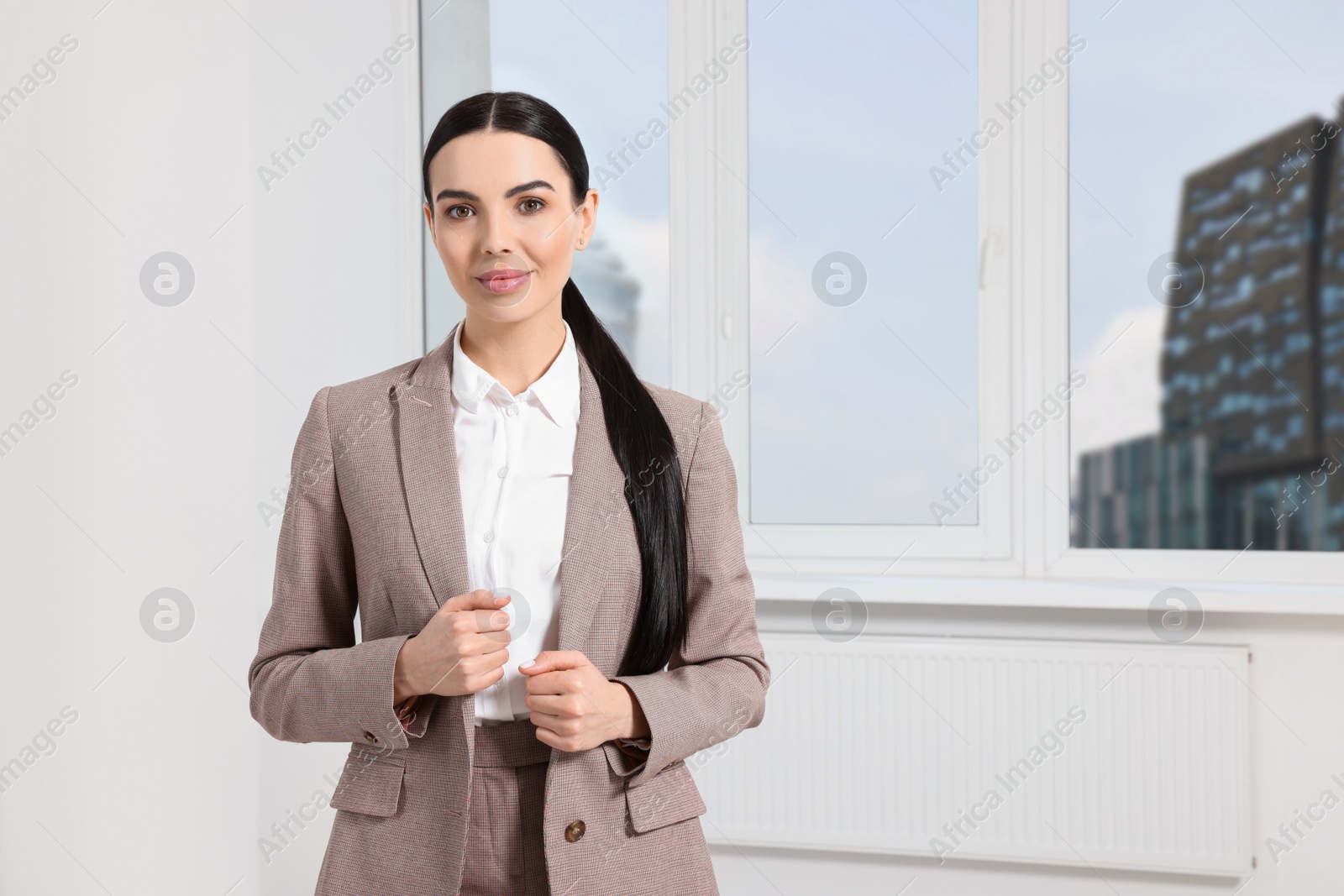 Photo of Beautiful real estate agent in nice suit indoors, space for text