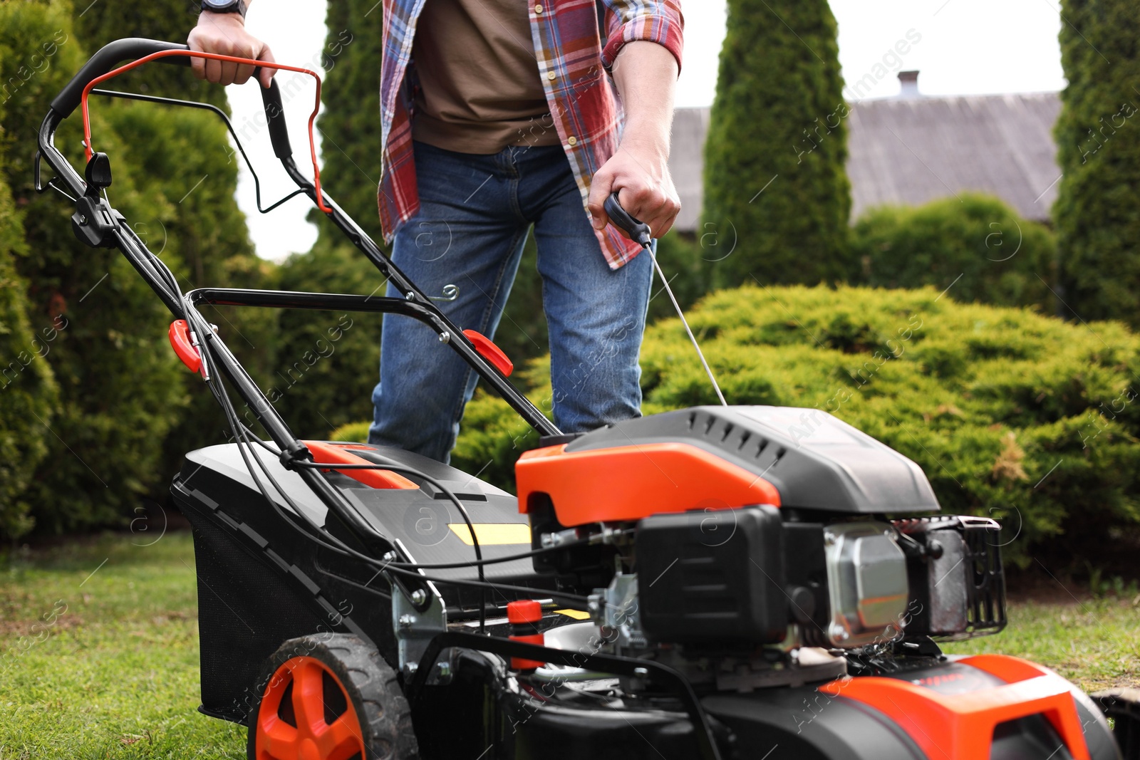 Photo of Man with modern lawn mower in garden, closeup