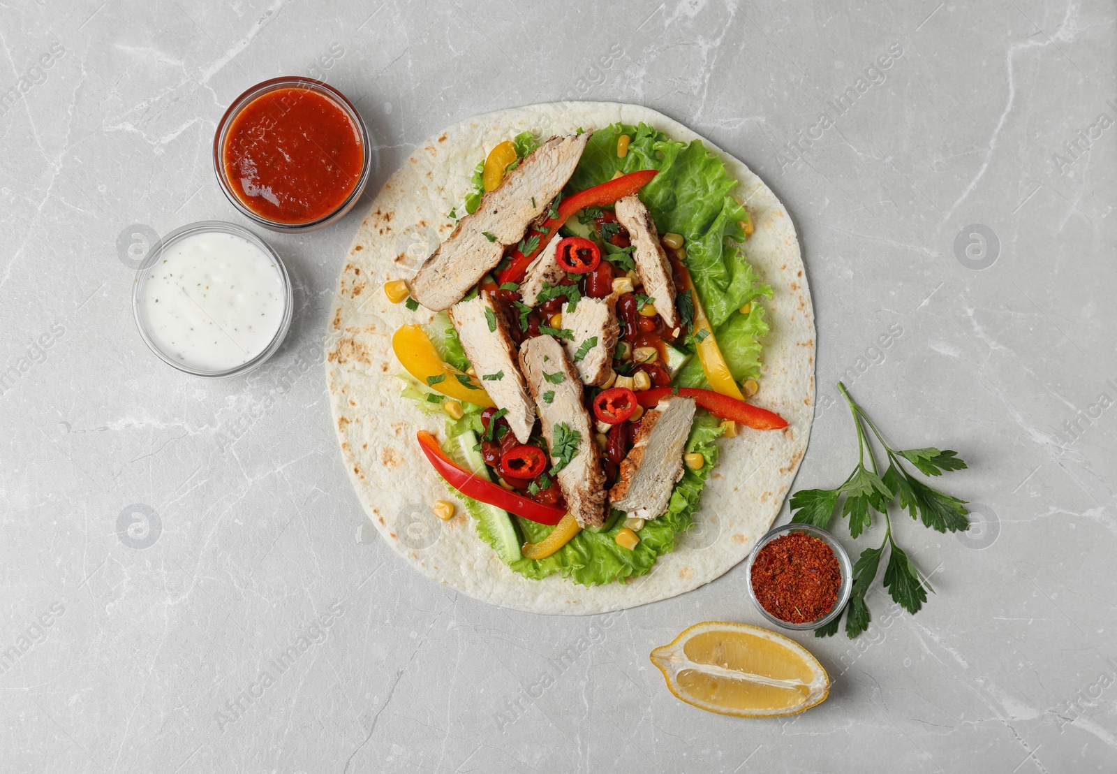 Photo of Delicious tortilla with meat on light table, flat lay