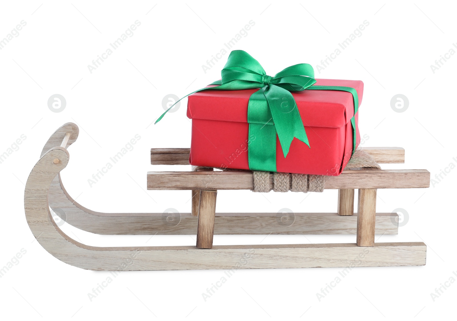 Photo of Wooden sleigh with gift box isolated on white. Christmas holiday decor