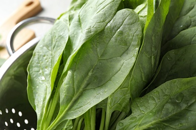 Colander with fresh green healthy spinach, closeup view