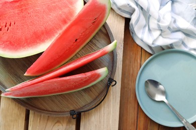 Photo of Sliced fresh juicy watermelon on wooden table, flat lay