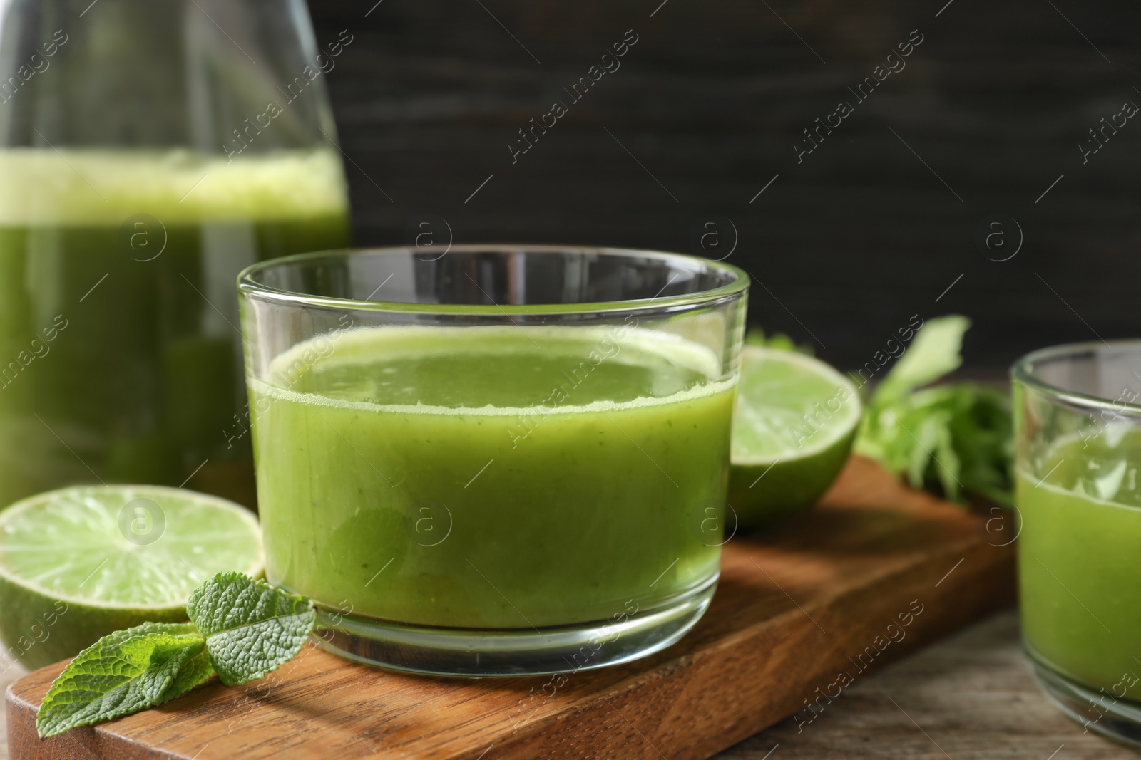 Photo of Glass with delicious detox juice and ingredients on table, closeup