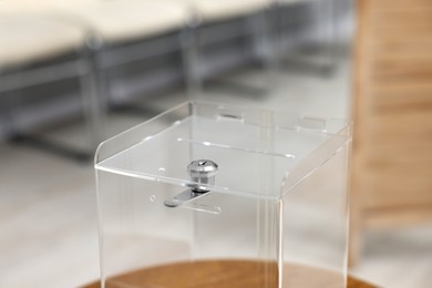 Photo of Transparent ballot box on blurred background, closeup