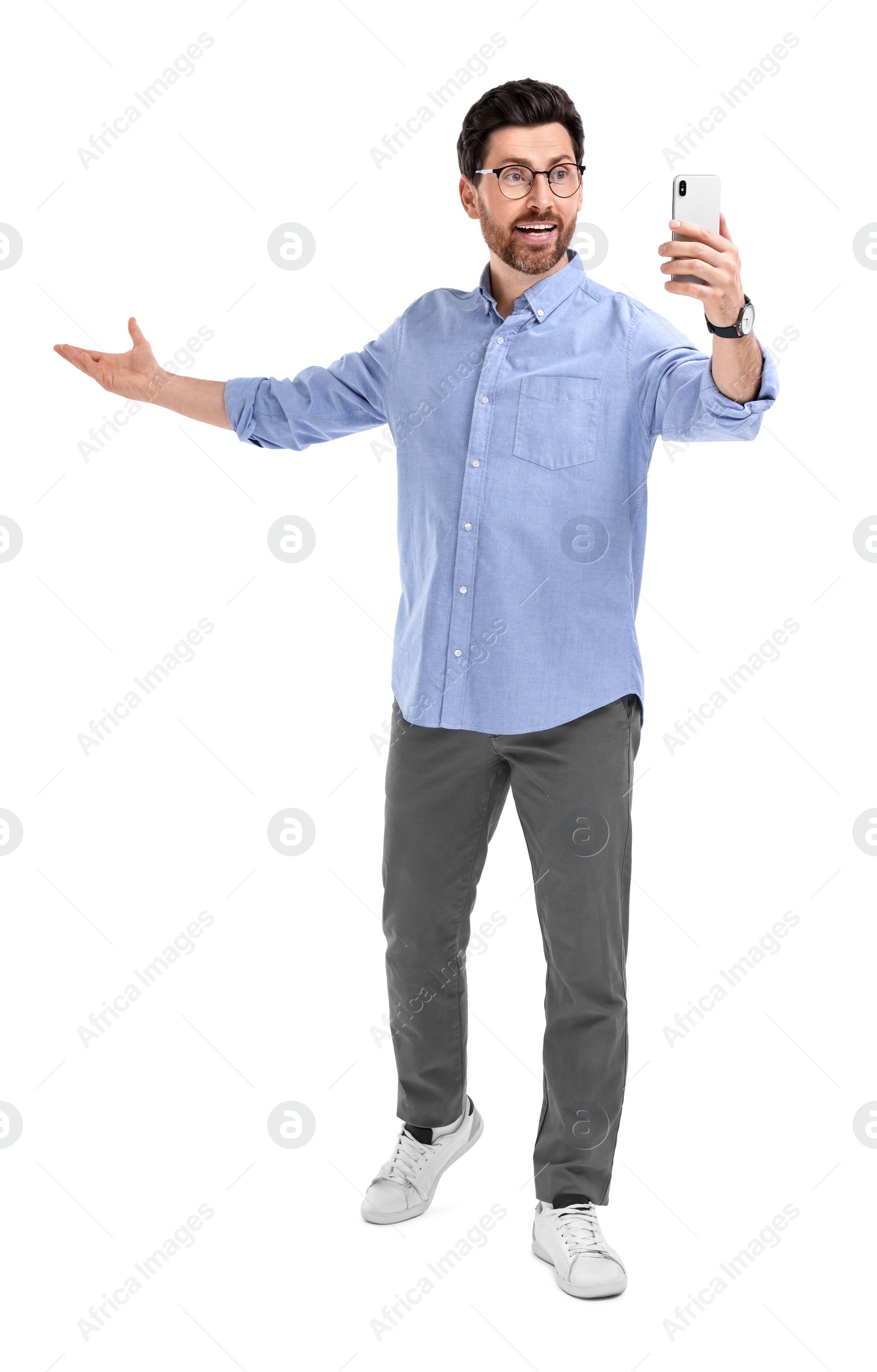 Photo of Smiling man taking selfie with smartphone on white background