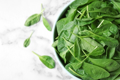 Photo of Fresh green healthy spinach on white marble table, top view. Space for text