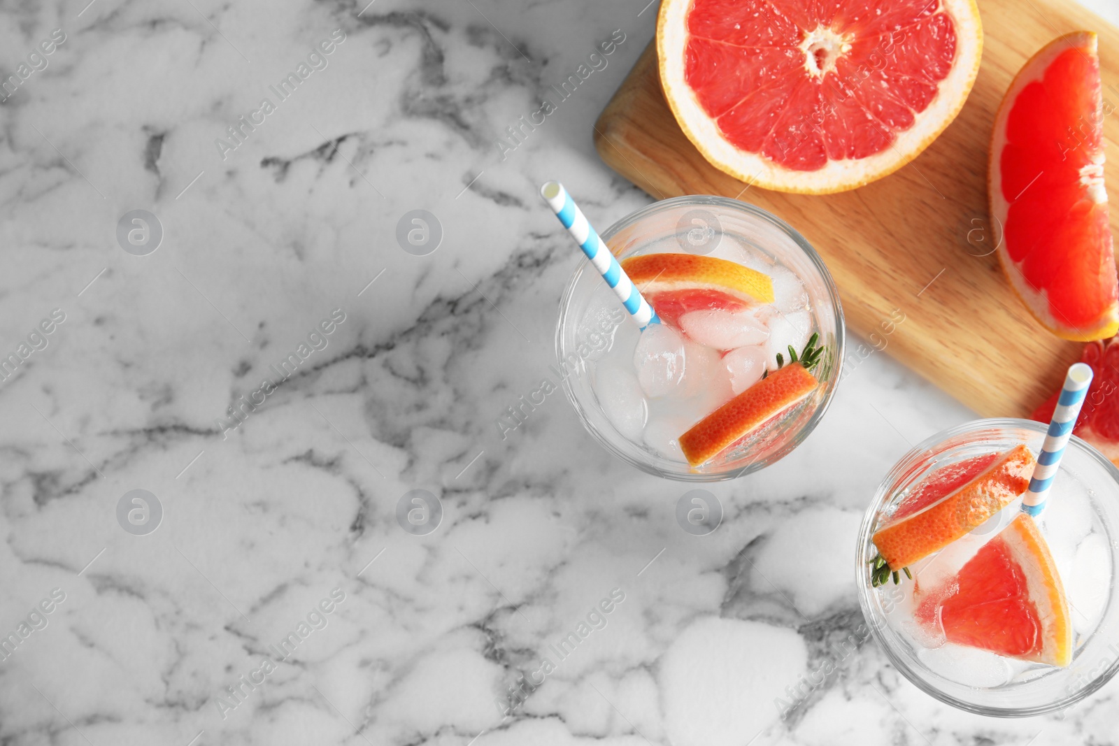 Photo of Flat lay composition with glasses of infused water and grapefruits on marble background. Space for text