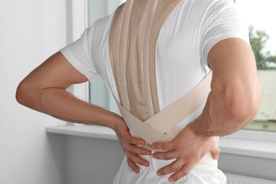 Photo of Closeup view of man with orthopedic corset in room