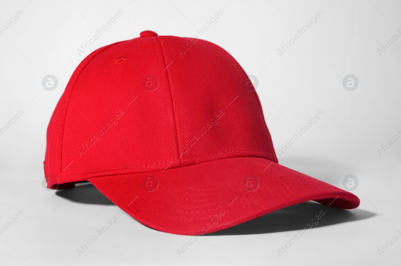 Photo of Stylish red baseball cap on white background