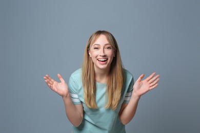 Photo of Beautiful young woman laughing on grey background. Funny joke