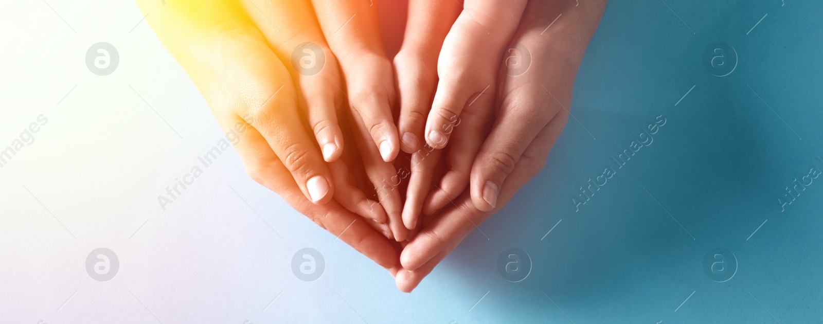 Image of Happy family holding hands on blue background, top view. Banner design 