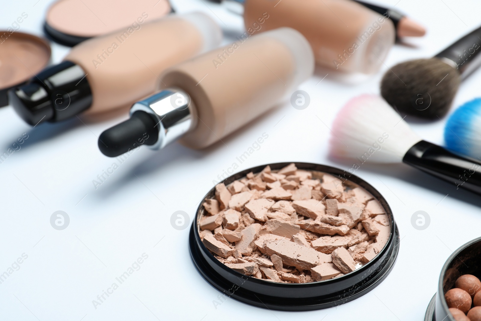 Photo of Composition with skin foundation, powder and beauty accessories on white background