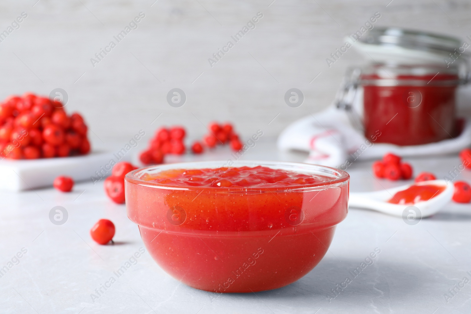 Photo of Delicious rowan jam in glass bowl on light table