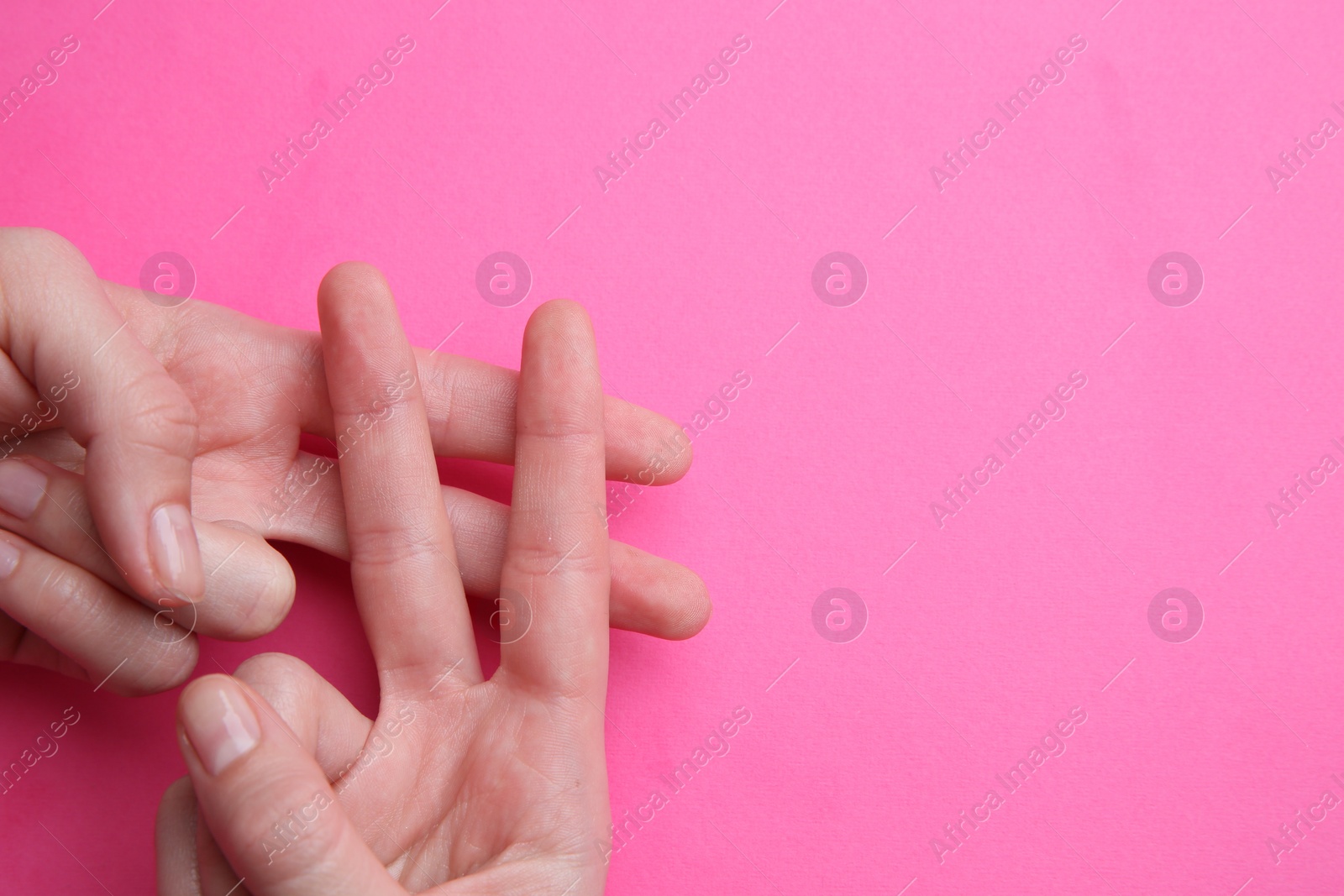 Photo of Woman making hashtag symbol with her hands on pink background, top view. Space for text