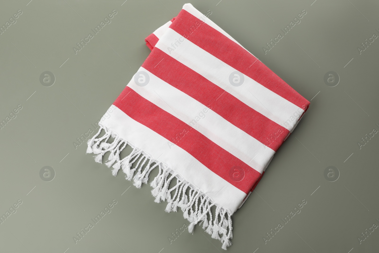 Photo of Folded striped beach towel on grey background, top view