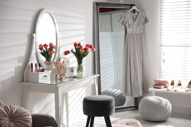 Stylish room interior with elegant dressing table and mirror