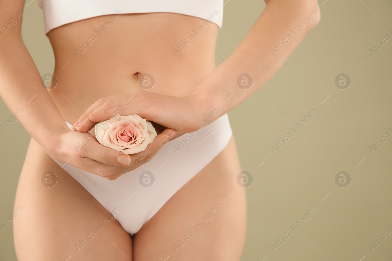 Photo of Gynecology. Woman in underwear with rose flower on green background, closeup. Space for text