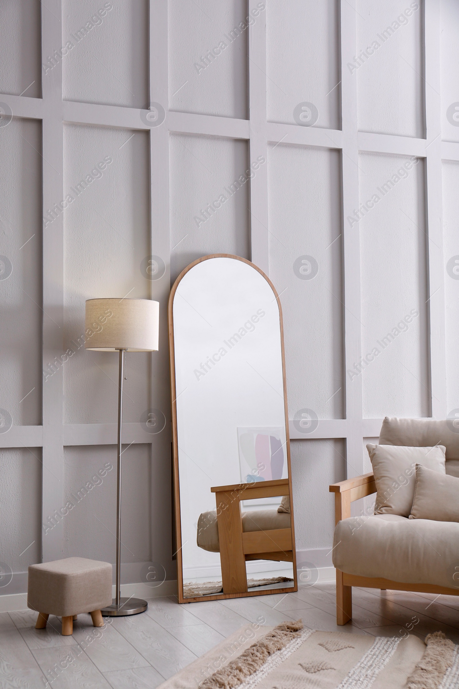 Photo of Light room interior with large mirror near wall