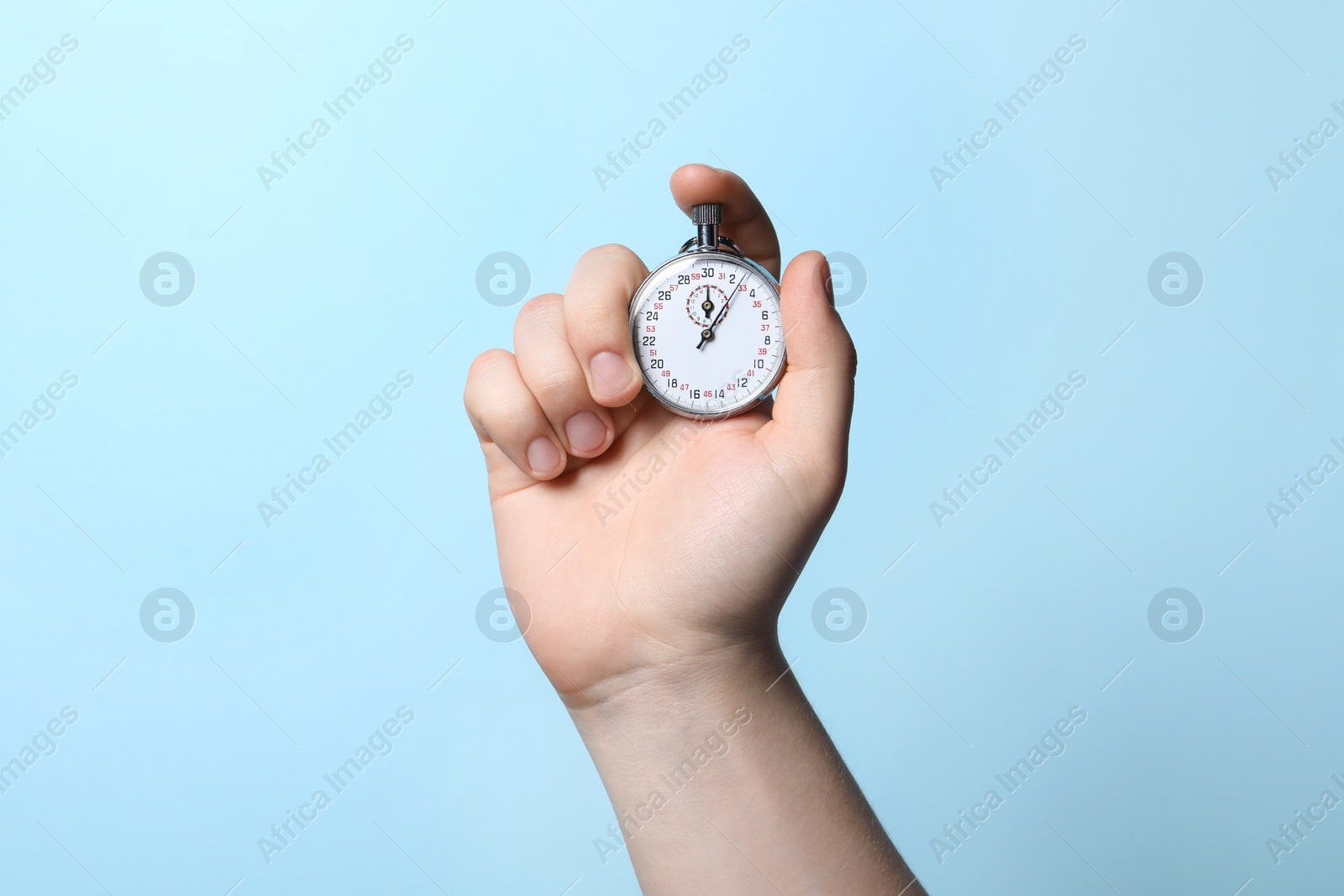 Photo of Man holding vintage timer on light blue background, closeup